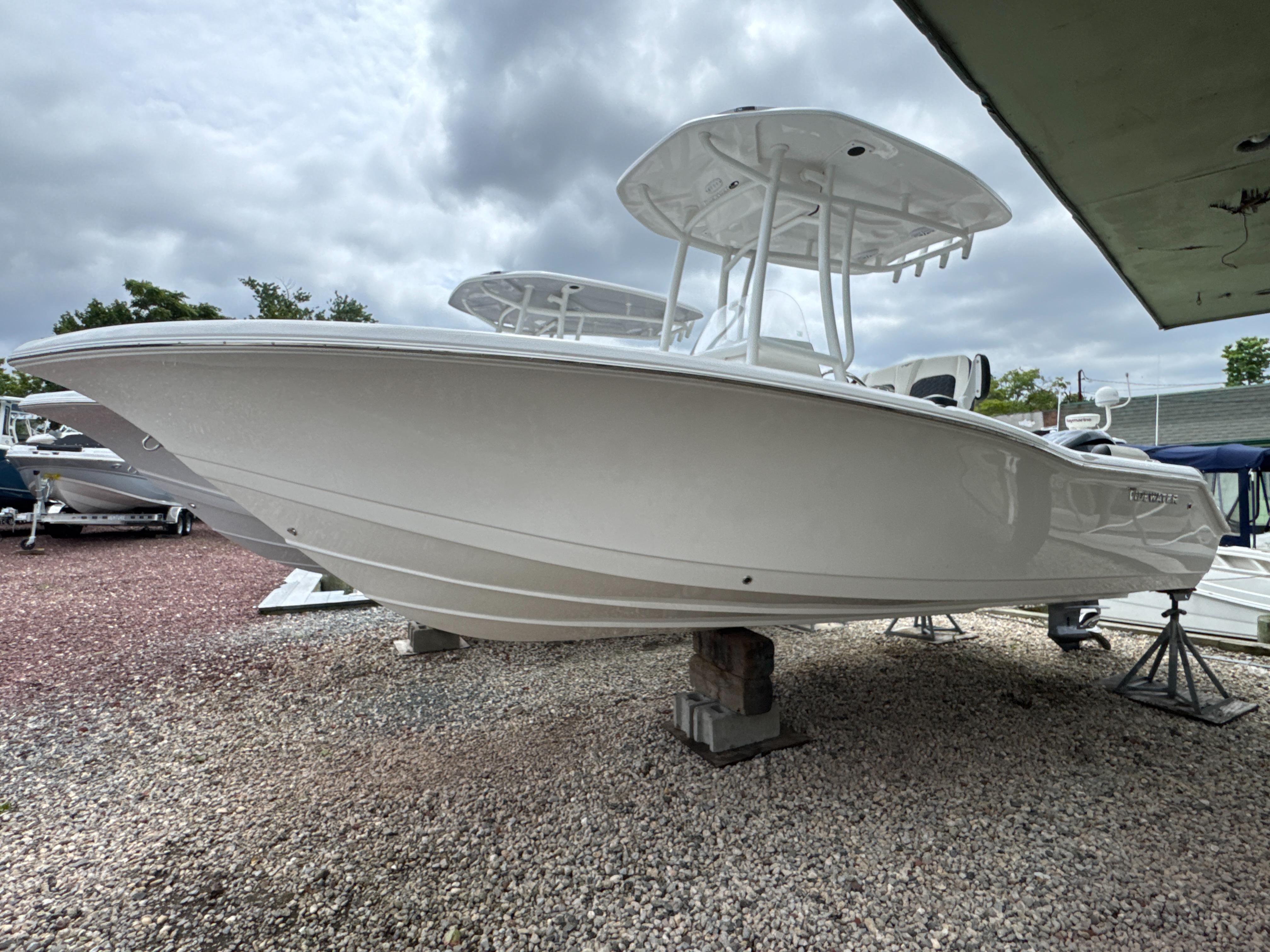 Tidewater 210 LXF 2025 Tidewater 210 LXF boat displayed on gravel under cloudy sky.