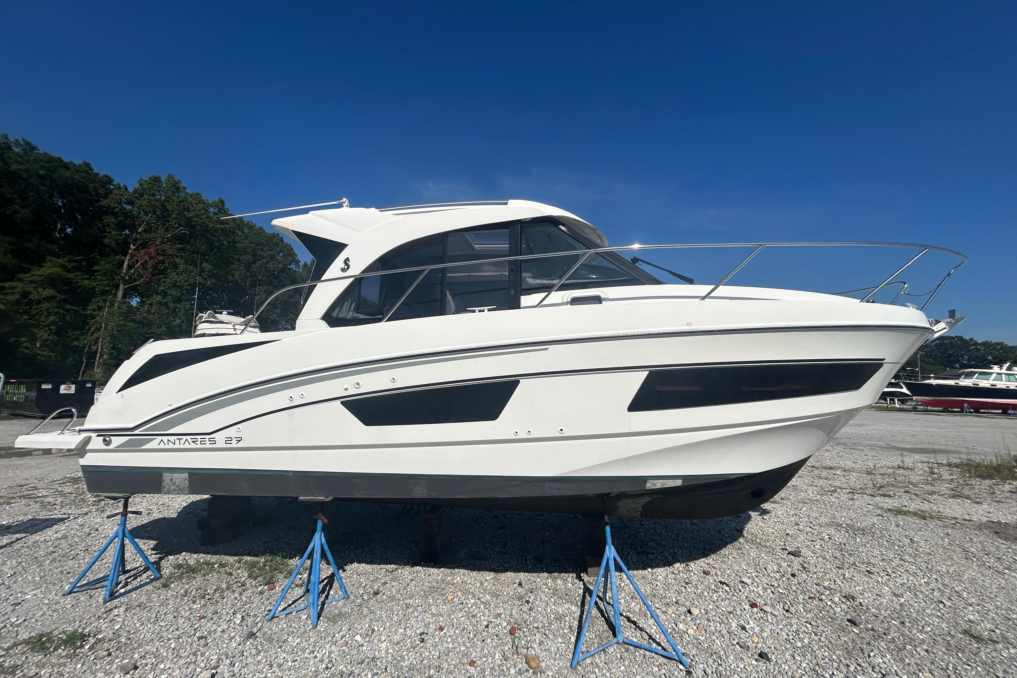 Beneteau Antares 2020 Beneteau Antares boat on stands, displayed outdoors under clear blue sky.