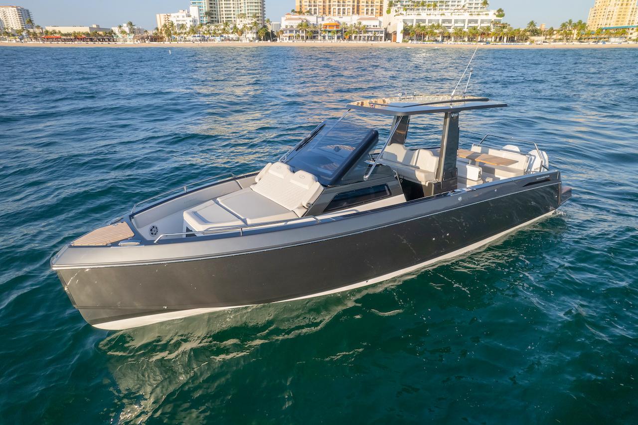 Schaefer V33 2025 Schaefer V33 luxury boat on the water near a coastal city.