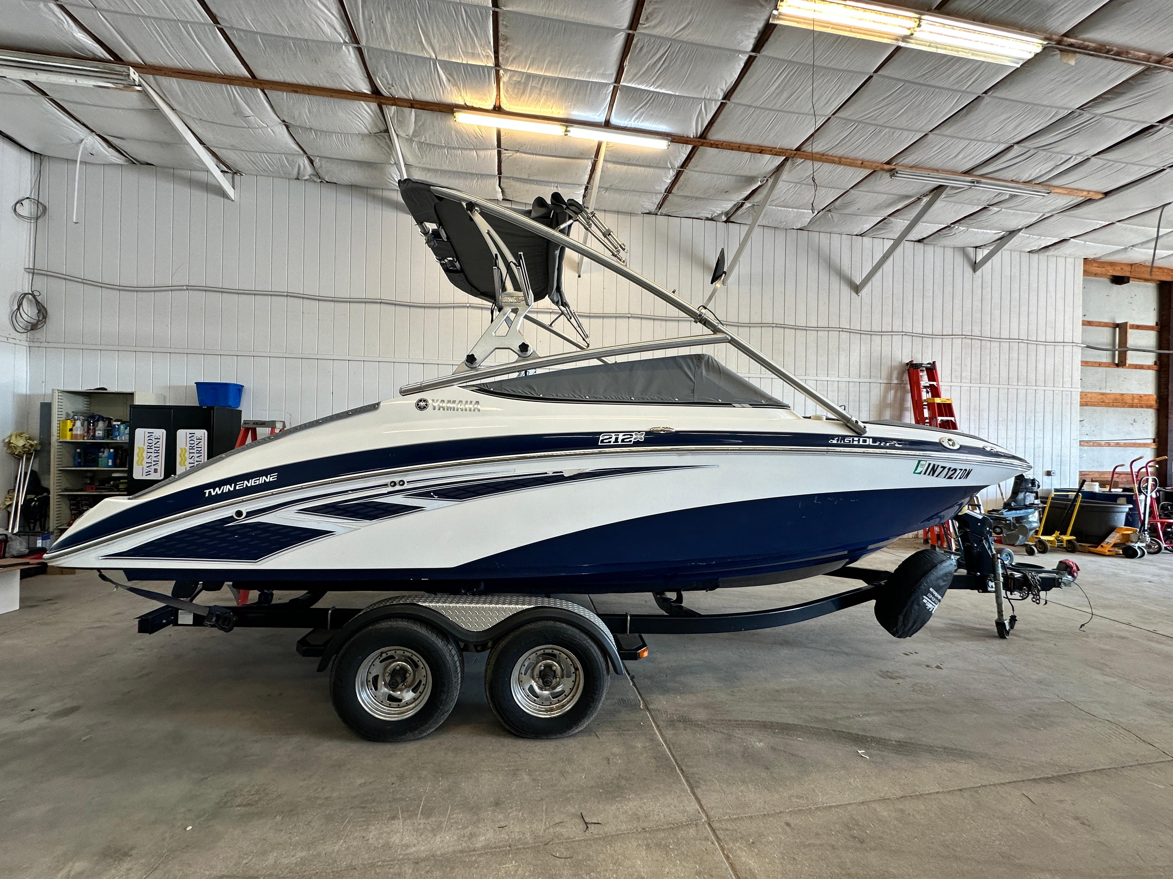 Yamaha Boats 212X 2012 Yamaha Boats 212X in a garage, featuring a sleek design and twin engines.