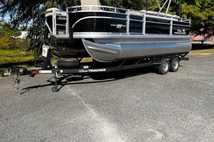 Sun Tracker SportFish 20 DLX 2025 Sun Tracker SportFish 20 DLX pontoon boat on trailer, parked outdoors.