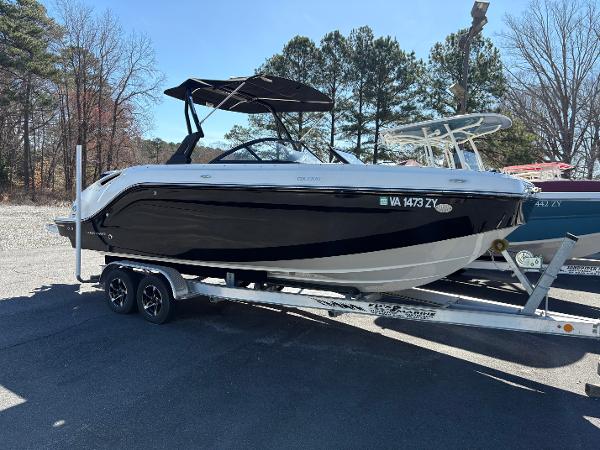 Bayliner DX2200 2021 Bayliner DX2200 boat on trailer, black and white design, parked outdoors.