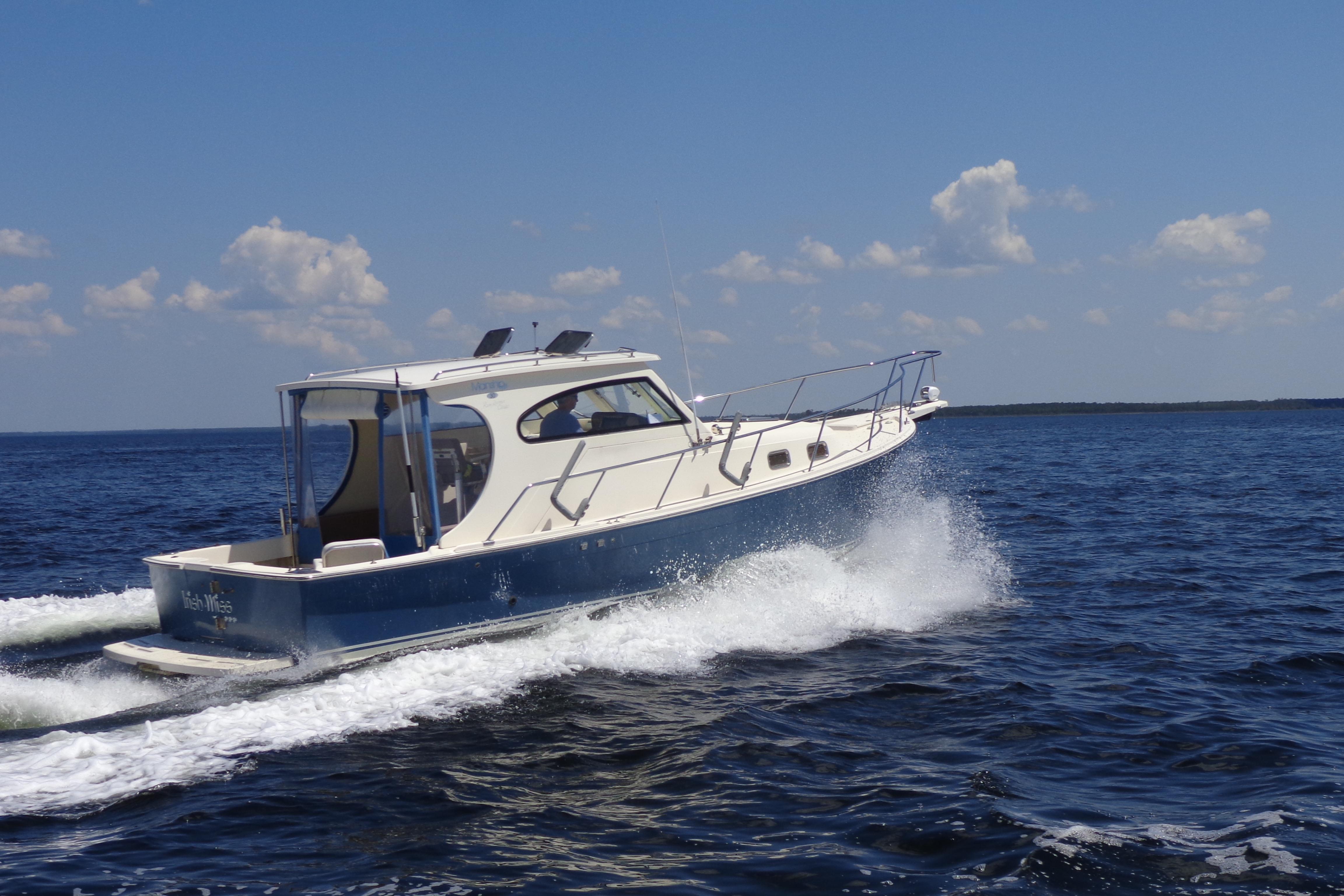 Mainship Pilot 30-II 2006 Mainship Pilot 30-II cruising on open water under a clear blue sky.