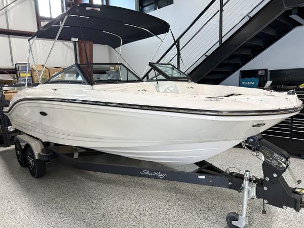 Sea Ray SPX 210 2023 Sea Ray SPX 210 boat on trailer, displayed indoors with black canopy.