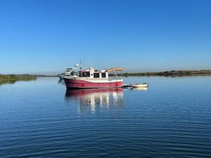 Ranger Tugs RANGER R-25 2009 Ranger Tugs RANGER R-25 boat anchored on calm water under clear blue sky.