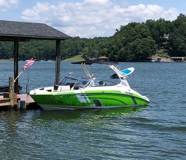 Yamaha Boats 212 XD 2021 Yamaha Boats 212 XD docked on a scenic lake with lush green surroundings.