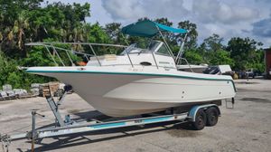 Key West 2300 Wa 2000 Key West 2300 WA Bluewater boat on trailer, parked outdoors with lush greenery background.