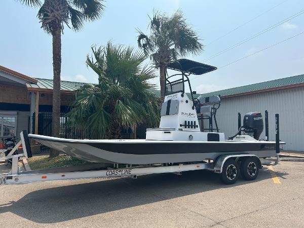 Shallow Stalker 240 RC Elite 2025 Shallow Stalker 240 RC Elite boat on trailer, parked near palm trees.