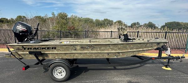 Tracker Grizzly 1654 T Sportsman 2025 Tracker Grizzly 1654 T Sportsman boat on trailer, camo design, parked outdoors.