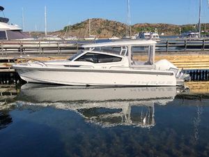 Nimbus Weekender 9 2022 Nimbus Weekender 9 boat docked in a marina, with scenic background and clear reflections.