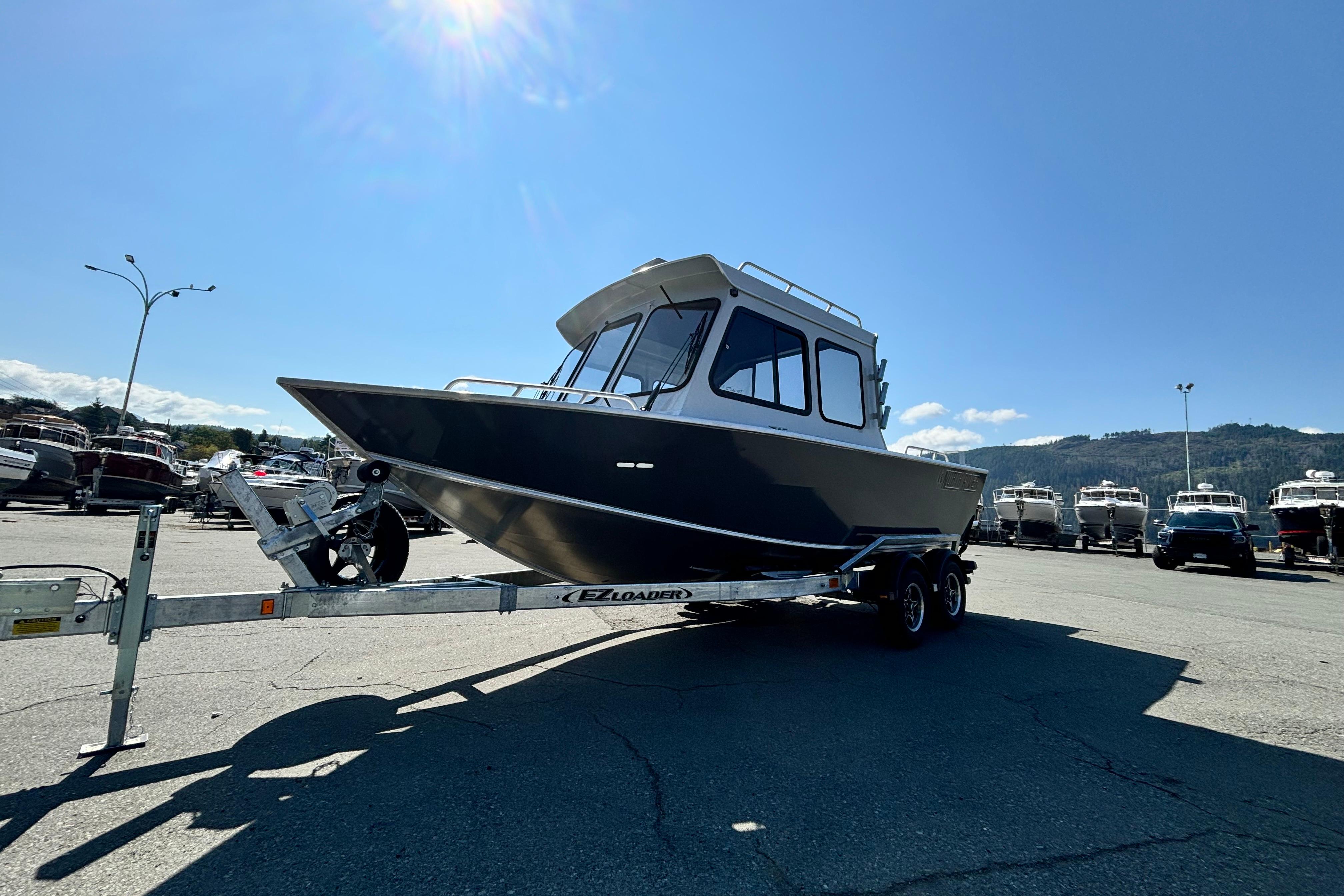 North River 21 Coho HT 2026 North River 21 Coho HT boat on trailer under clear blue sky.