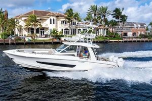 Boston Whaler 420 Outrage 2022 Boston Whaler 420 Outrage cruising near luxury waterfront homes.