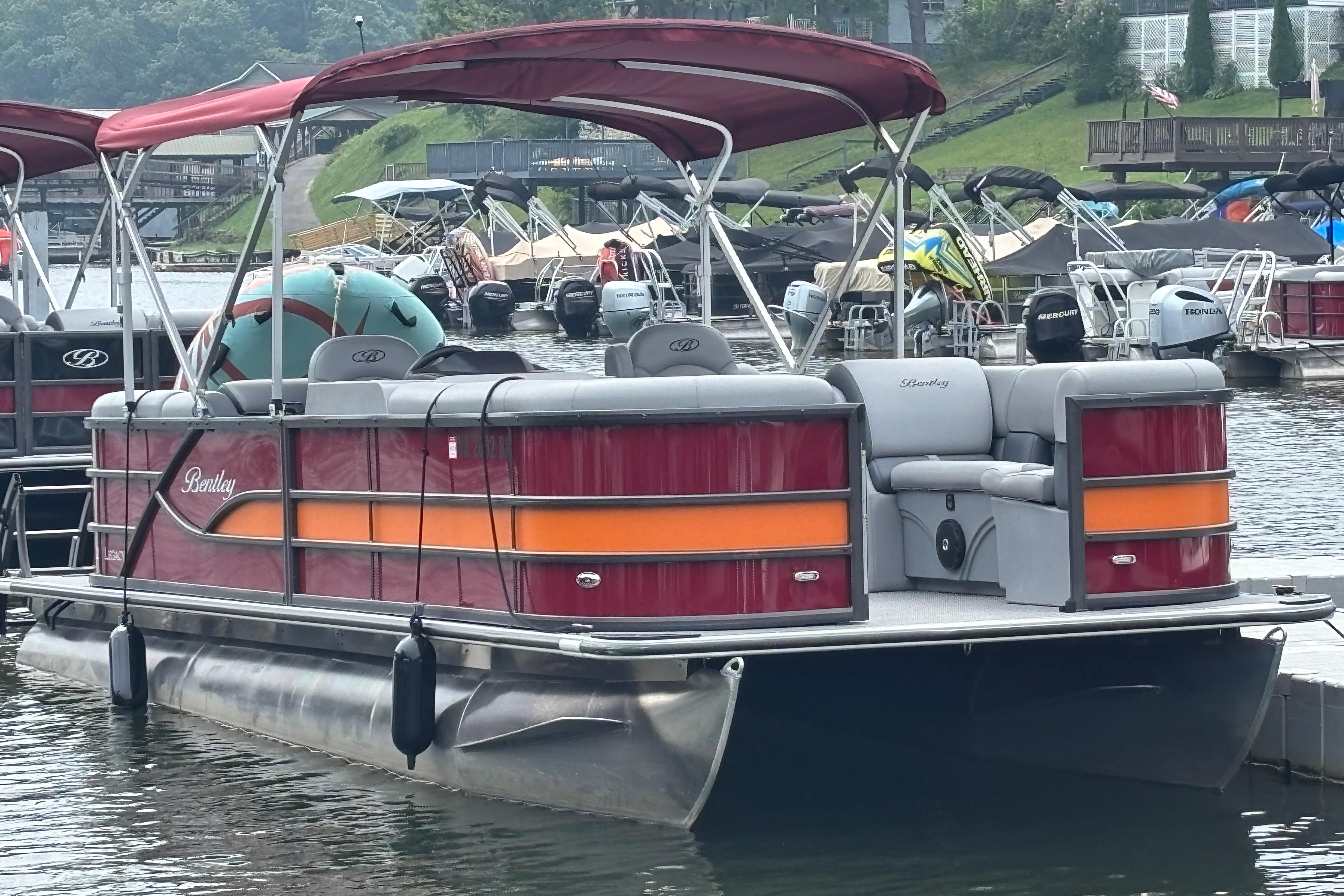 Bentley Pontoons Legacy Navigator 2025 Bentley Pontoons Legacy Navigator docked, featuring red and orange accents, with canopy.