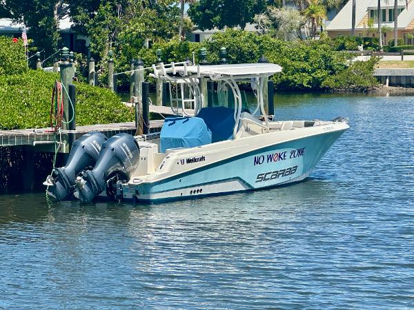 Wellcraft 262 Fisherman 2019 Wellcraft 262 Fisherman boat docked with twin engines, labeled "No Woke Zone."