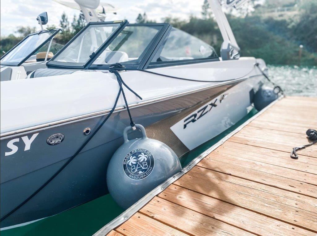 Tigé 23RZX 2021 Tigé 23RZX boat docked with fenders, on a sunny day.