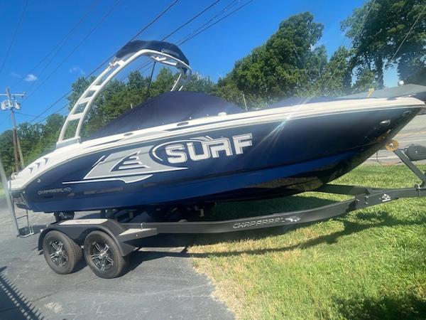 Chaparral 21 Surf 2023 Chaparral 21 Surf boat on trailer, parked on driveway, sunny day.