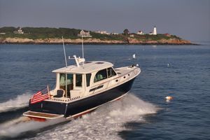 Back Cove 412 Back Cove 412 yacht cruising near a scenic coastline with lighthouse, 2026 model.