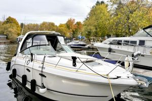 Chaparral 310 Signature 2004 Chaparral 310 Signature boat docked in a scenic marina with autumn foliage.