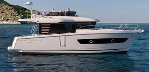 Beneteau ST 37 2026 Beneteau ST 37 Swift Trawler on serene ocean waters near a rocky coastline.