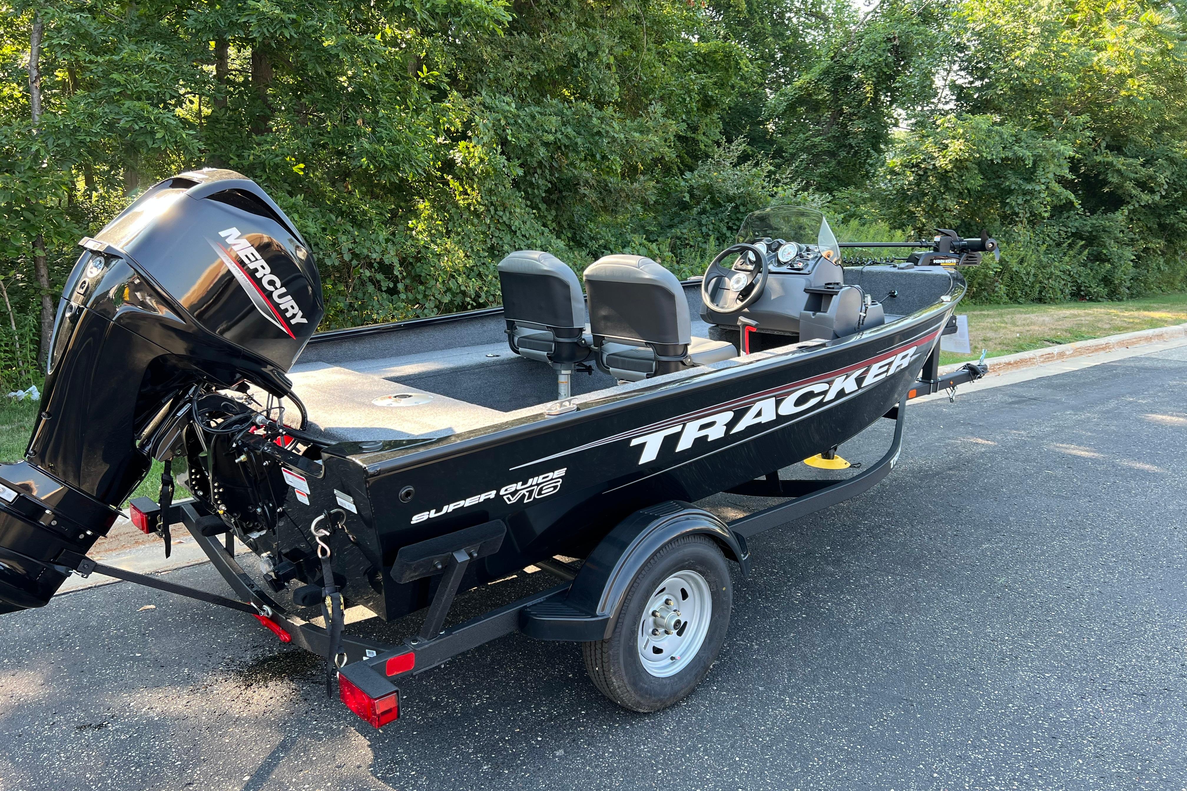 Tracker Super Guide V-16 SC 2026 Tracker Super Guide V-16 SC boat with Mercury engine on trailer, parked outdoors.
