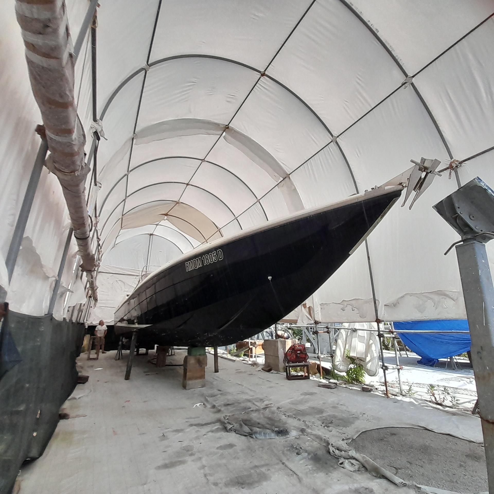 Tecnomar Benetti 50 offshore 1989 Tecnomar Benetti 50 offshore yacht in covered storage, side view.