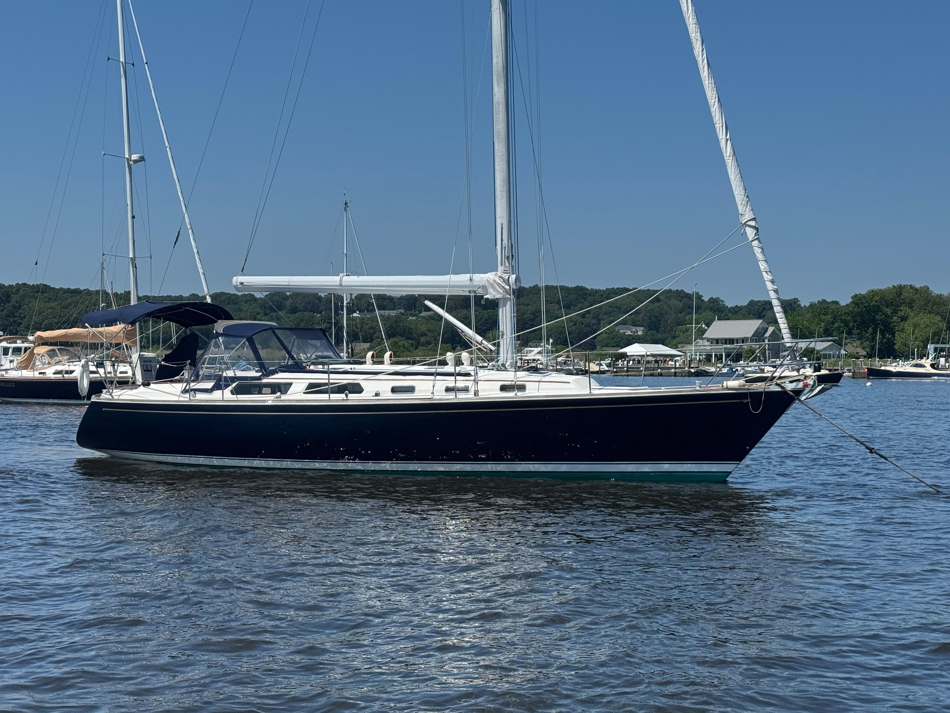 Sabre 42 1987 Sabre 42 sailboat anchored on calm water under clear blue sky.