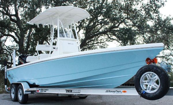 Pathfinder 2300 HPS 2024 Pathfinder 2300 HPS boat on trailer, light blue hull, white T-top, parked outdoors.