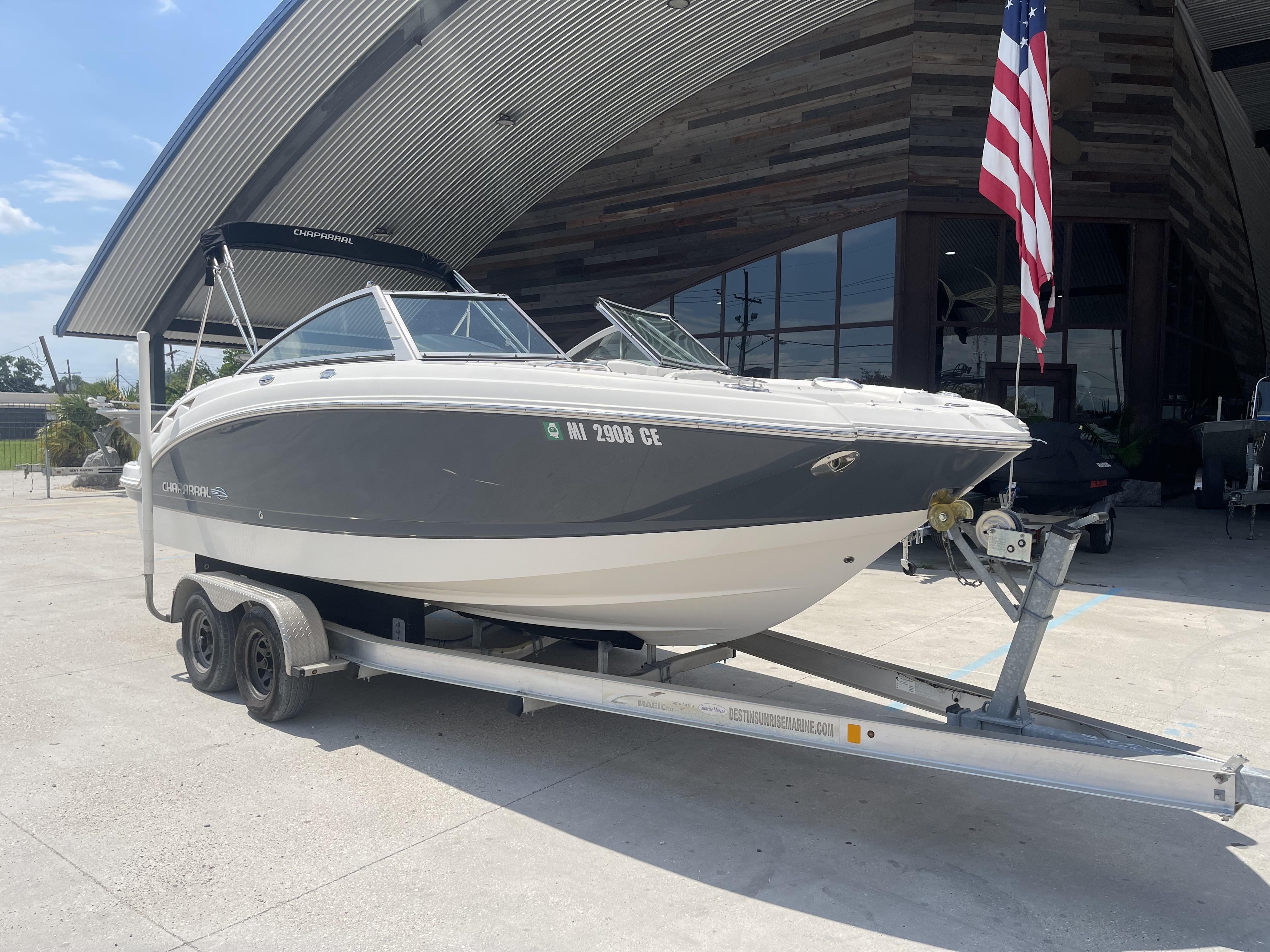 Chaparral Sunesta 224 2014 Chaparral Sunesta 224 boat on trailer, parked outside a modern building.