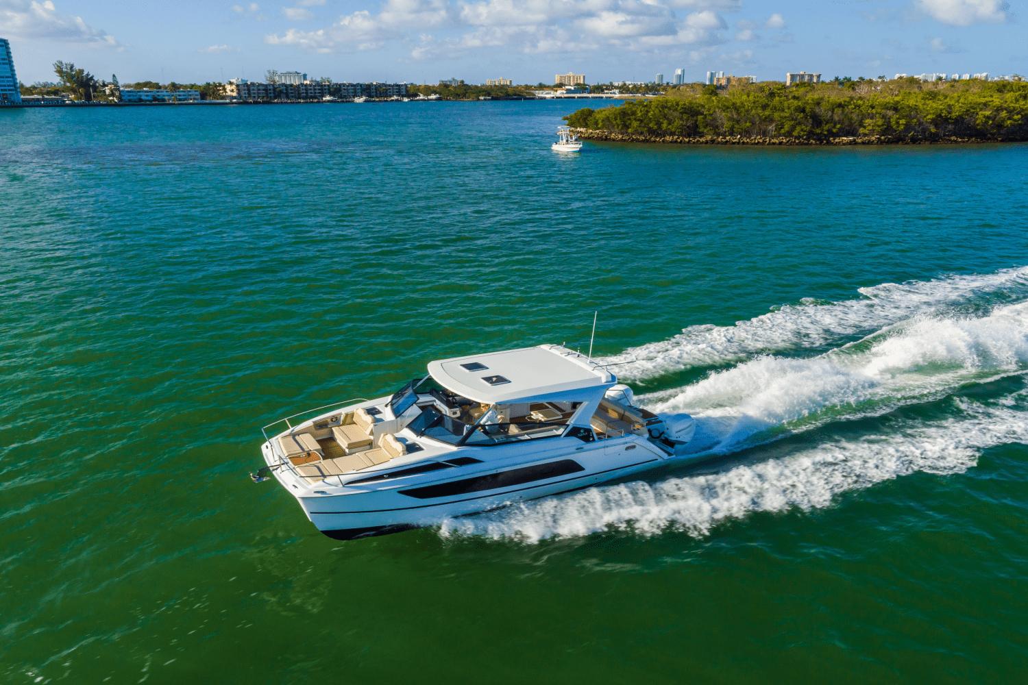 Aquila 36 Sport 2024 Aquila 36 Sport cruising on clear blue water near a lush island.
