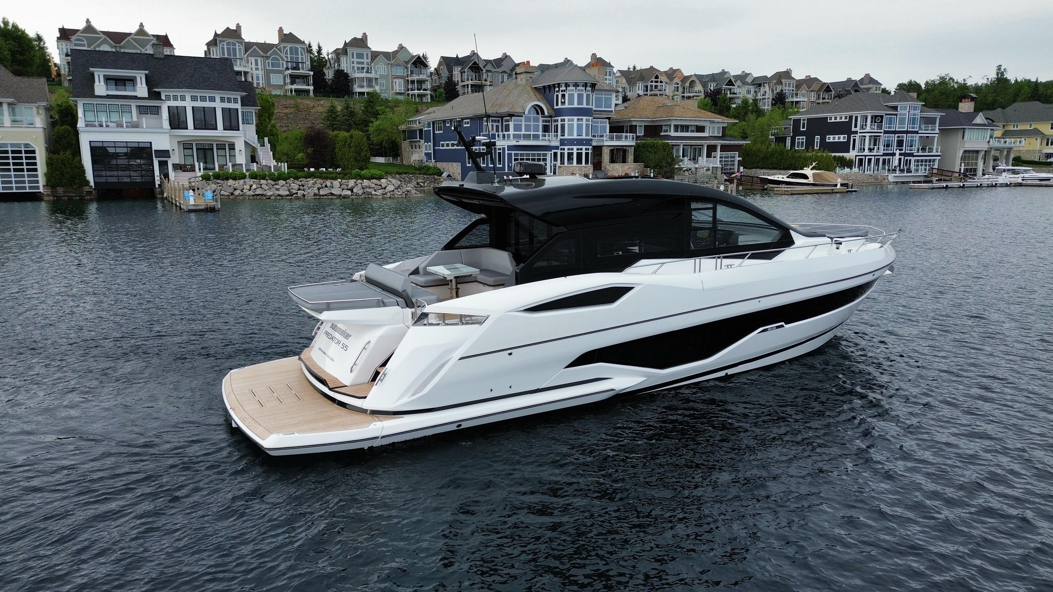 Sunseeker Predator 55 2026 Sunseeker Predator 55 yacht docked near luxury waterfront homes.