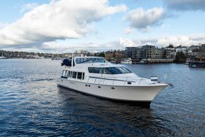 Pacific Mariner 65 Diamond 2005 Pacific Mariner 65 Diamond yacht cruising on a scenic waterfront with cloudy skies.