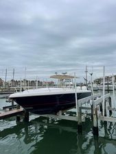 Intrepid 323 Cuddy 2008 Intrepid 323 Cuddy boat docked at marina under cloudy sky.