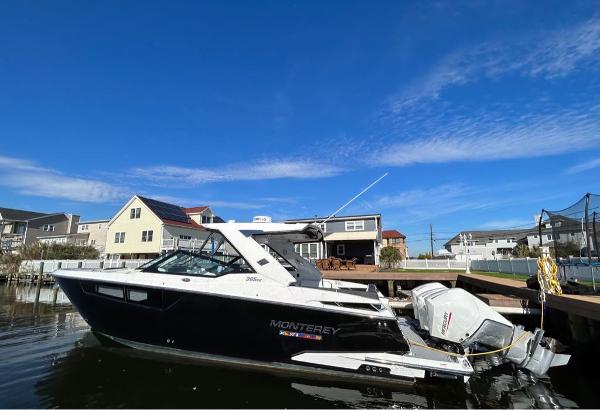Monterey 385 SE 2019 Monterey 385 SE boat docked near waterfront homes under a clear blue sky.