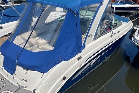 Chaparral 256 SSi 2008 Chaparral 256 SSi boat with blue canopy docked in marina.