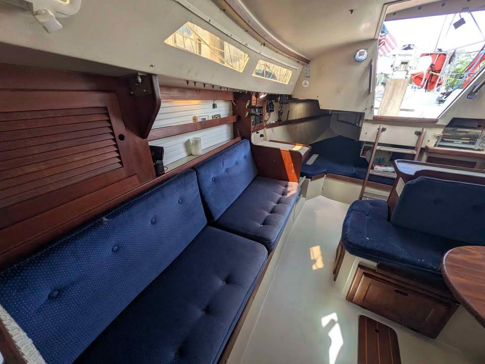 Catalina 30 Interior of a 1988 Catalina 30 sailboat with blue cushioned seating and wooden cabinetry.