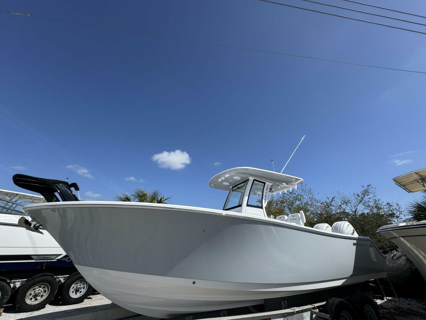Sportsman Open 252 Center Console 2025 Sportsman 252 Open boat under clear blue sky, side view.