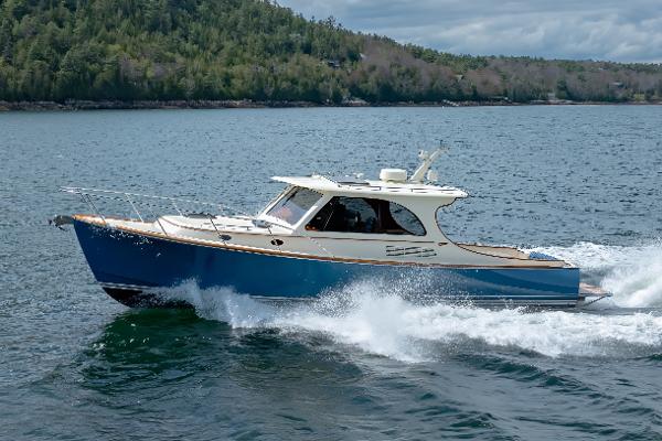 Hinckley Picnic Boat 40 2024 Hinckley Picnic Boat 40 cruising on a scenic lake with forested shoreline.