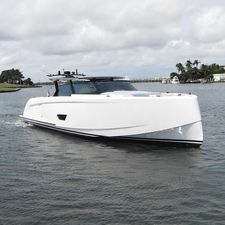 Vanquish 58 2024 Vanquish 58 yacht cruising on a scenic waterway under a cloudy sky.