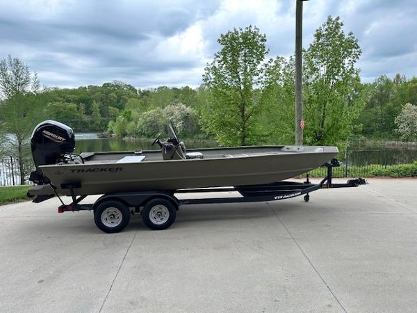 Tracker Grizzly 2072 CC 2025 Tracker Grizzly 2072 CC boat on trailer, parked near a scenic lake.