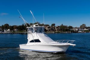 Luhrs 36 Convertible 2007 Luhrs Tournament 360 Open boat cruising on a sunny day near waterfront homes.