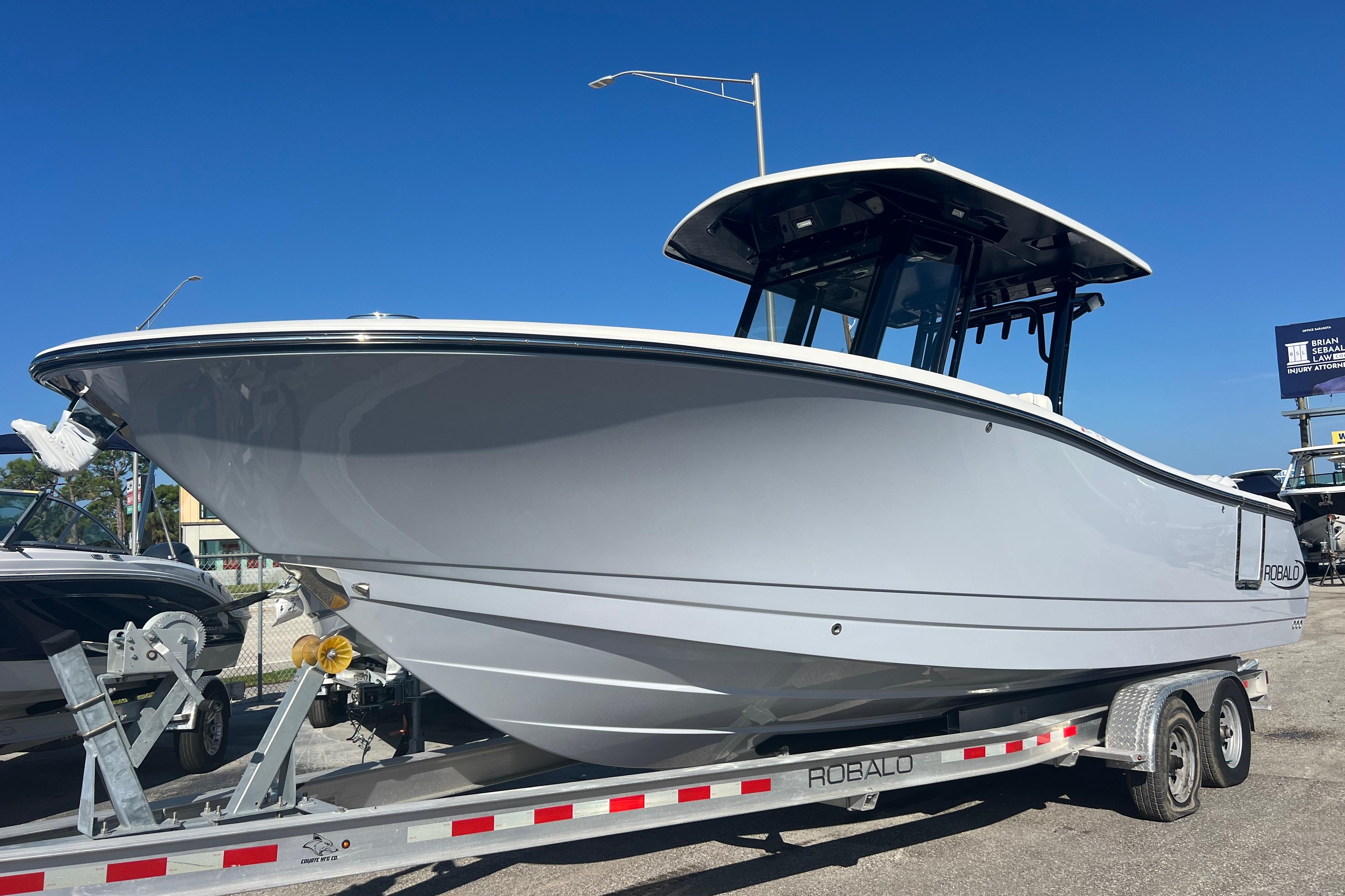 Robalo R270 Center Console 2025 Robalo R270 Center Console boat on trailer under clear blue sky.