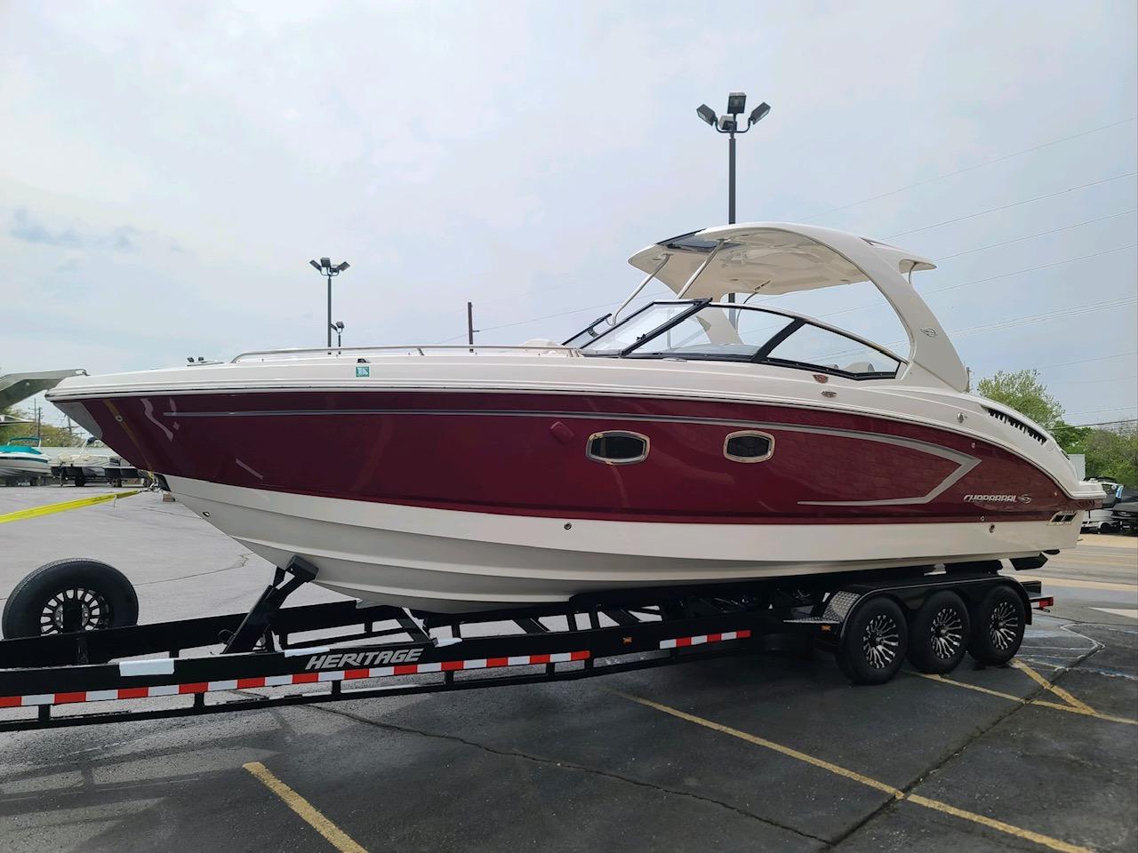 Chaparral 327 SSX 2013 Chaparral 327 SSX boat on trailer, red and white exterior, parked outdoors.