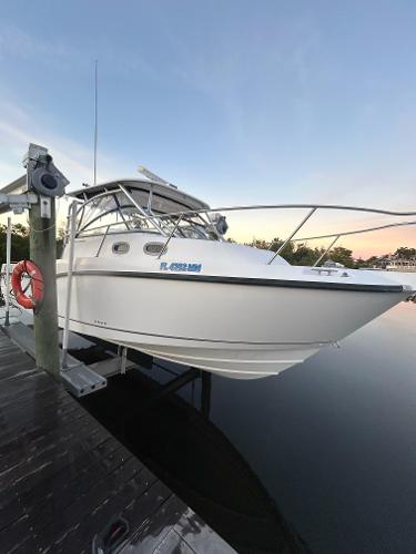 Boston Whaler 305 Conquest 2004 Boston Whaler Conquest 305 boat docked at sunset, featuring sleek design and sturdy build.