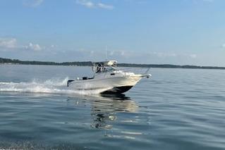 Robalo R235 2005 Robalo R235 boat cruising on calm water under a clear blue sky.