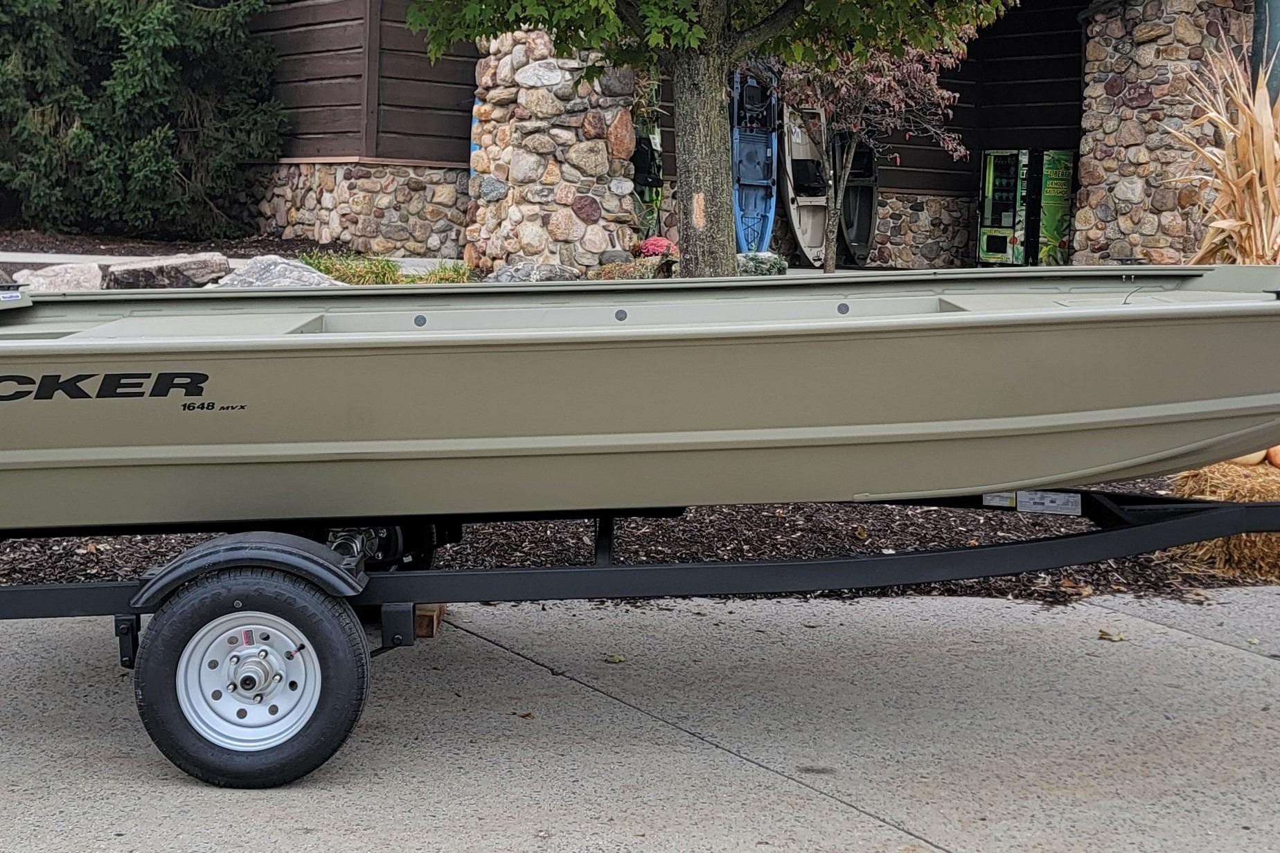 Tracker Grizzly 1648 Utility 2026 Tracker Grizzly 1648 Utility boat on trailer, parked outdoors near stone building.