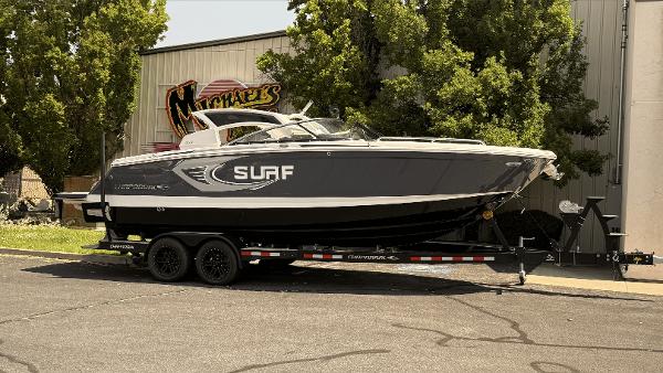 Chaparral 28 Surf 2023 Chaparral 28 Surf boat on trailer, parked outdoors near a building.