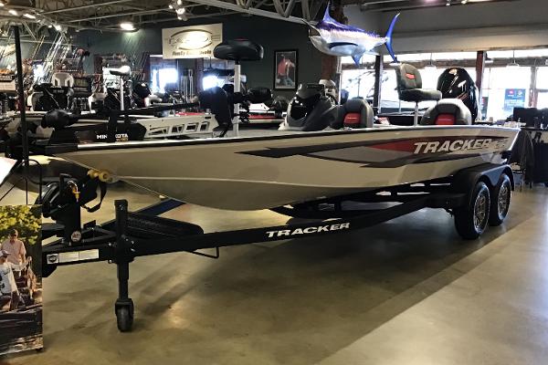 Tracker Savage 215 2025 Tracker Savage 215 boat displayed in a showroom with fishing equipment.