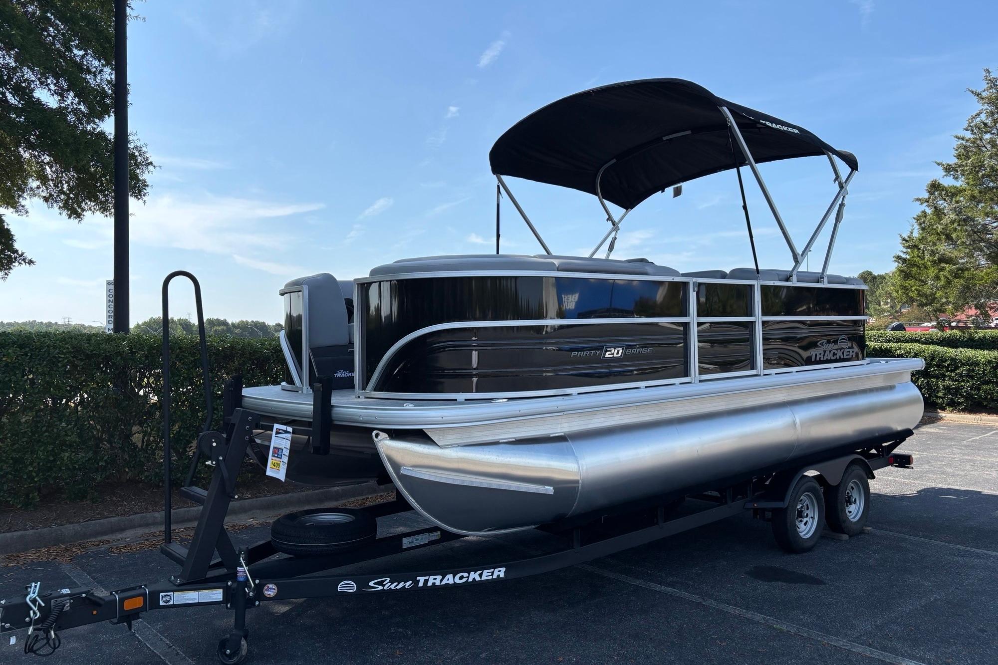 Sun Tracker Party Barge 20 DLX 2026 Sun Tracker Party Barge 20 DLX pontoon boat on trailer, parked outdoors.