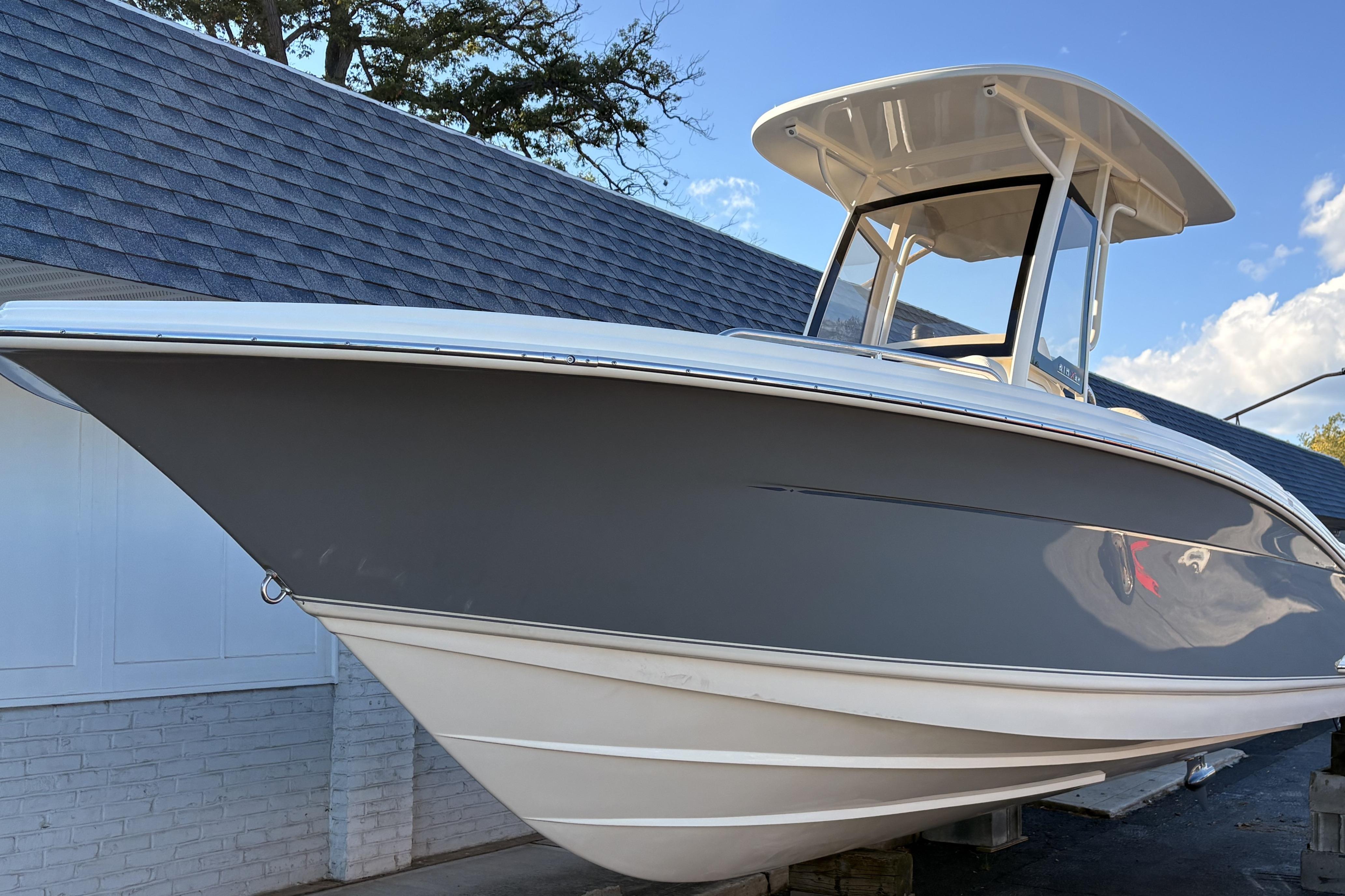 Scout 215 XSF 2026 Scout 215 XSF boat with sleek design, docked under a clear blue sky.