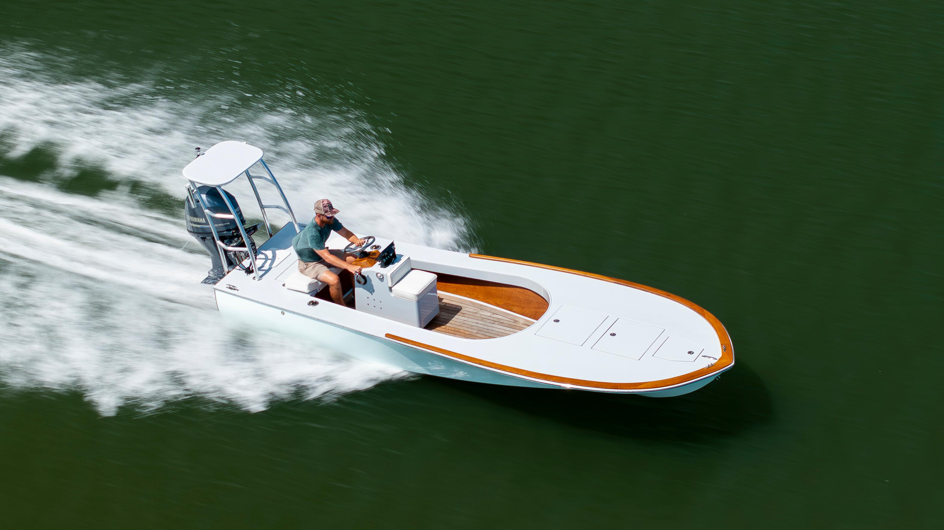 Custom Carolina 18 Flats 2023 Custom Carolina 18 Flats boat speeding on water, showcasing sleek design and performance.